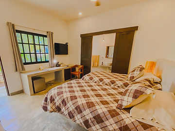 Room with two beds, window and TV