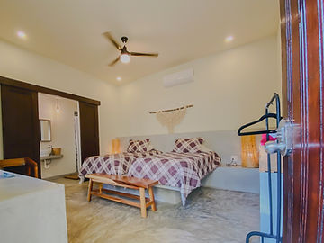 Doble Individual room with two beds and plaid bedspreads