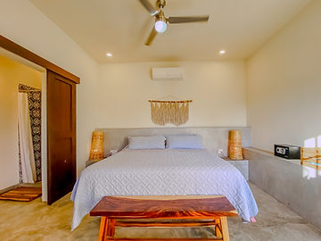 King bed with macramé headboard and bedside lamps