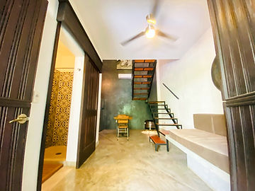 Entrada de loft con escalera y arte mexicano