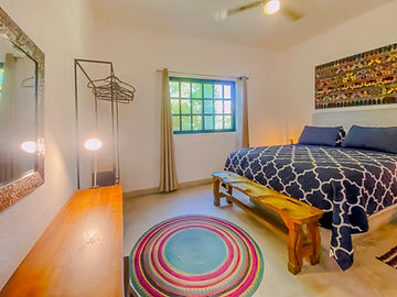 Recámara del loft con cama y colcha azul marino