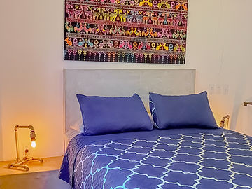 Cama con cojines azules y lámpara