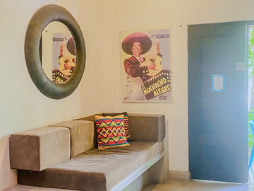 Sofá con cojines y pintura mexicana en la sala del loft